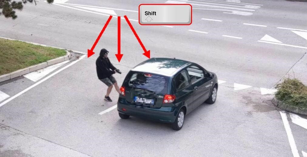 a man holding a gun approaches a car