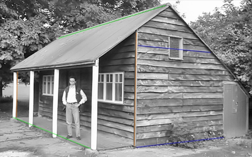 image of a man standing next to a wooden house and lines across the house highlighted in different colors